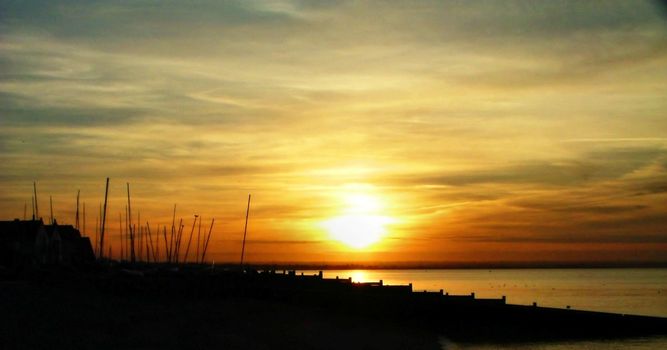 Setting sun settles over whitstable harbour towards seasalter