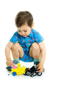 portrait of a cute happy three year old boy playing with toy motorcycles