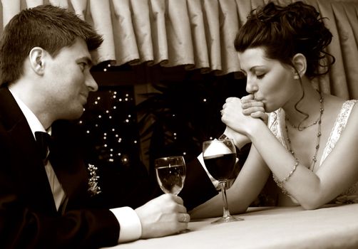 Recently married pair at restaurant in celebrating on romantic date. b/w+sepia
