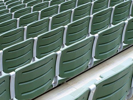 Rows of green stadium seats view from the top row.