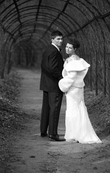 The groom and the bride walk in park. b/w