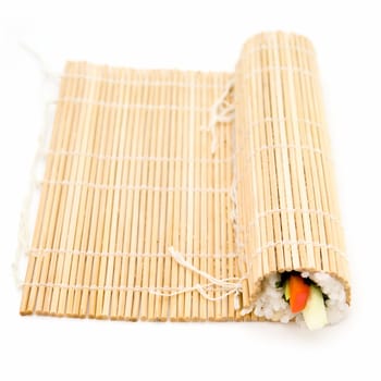 Cooking sushi. Bamboo rug on a white background