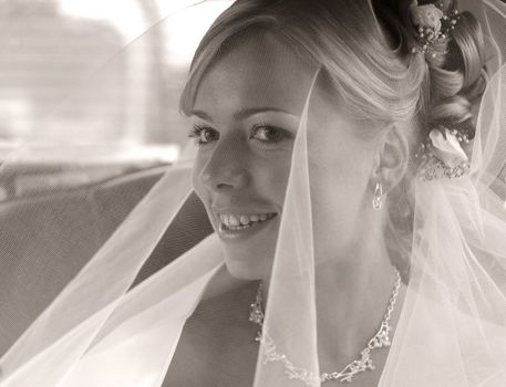 The beautiful bride under a veil. b/w+sepia