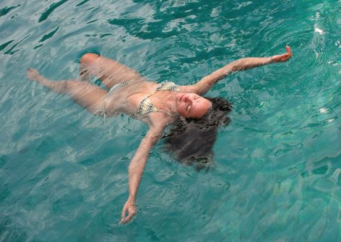 Beautiful woman enjoying summer in the pool