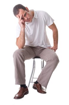 A young man, sitting on a stool, thinking. Isolated on white background.