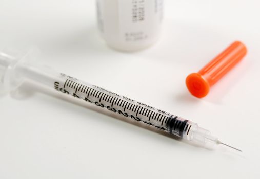 Syringe and insulin on white background.