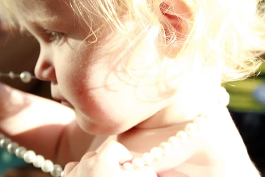 child playing with pearls. 