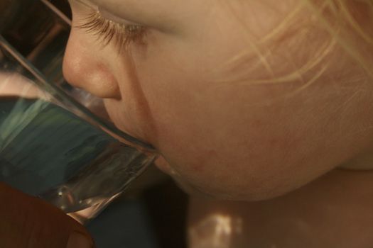 child drinking water from a glass