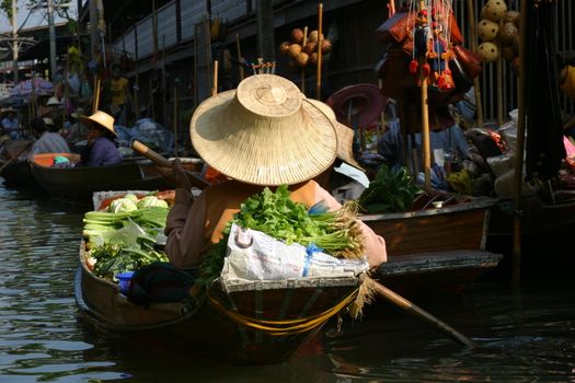 Woman in her boat selling her fresh vegetables at the Damnoen Saduak floating market in Thailand which is one of the most famous floating markets but definitely not the most authentic