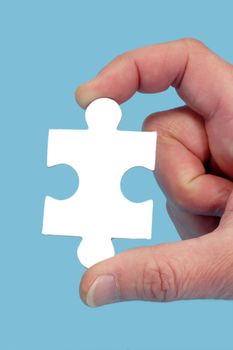 Hand and puzzle, isolated on blue background