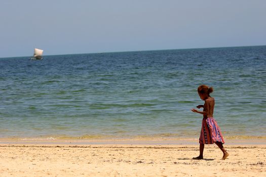 Young girl wandering along the beach at Ifaty