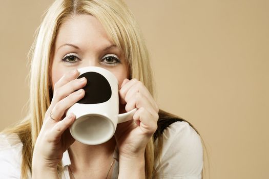Happy female having a drink of coffee, hot chocolate, or tea.
