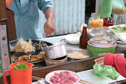 Preparing noodles at a stall at the market in Chinatown, Saigon