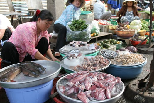 Woman washing the freshly caught fish at a stall in Vietnam
