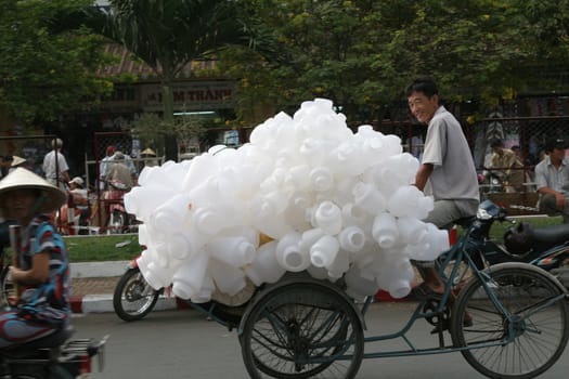 Man carrying a load of plastic bottles on his bike, Saigon, Vietnam