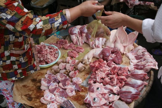 People trading at a market in the Mekong Delta, Vietnam at the butcher shop