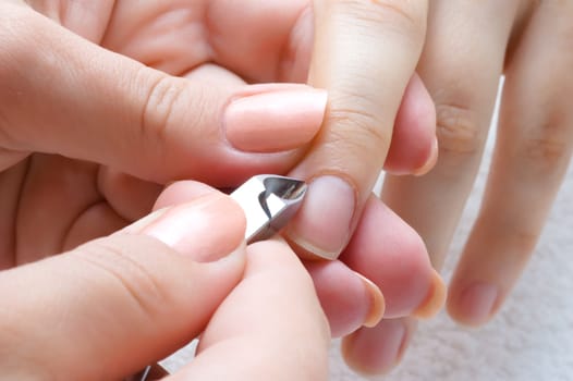 nail salon, cuticle cut on the female forefinger