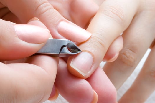 nail salon, cuticle cut on the female forefinger