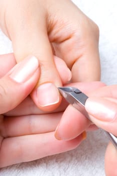 nail salon, cuticle cut on the female thumb