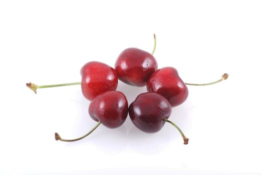 Five cherries isolated on a white background.