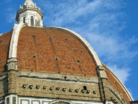 The dome of the Florence Duomo against a blue sky.