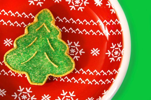 Green christmas tree cookie on a red holiday plate