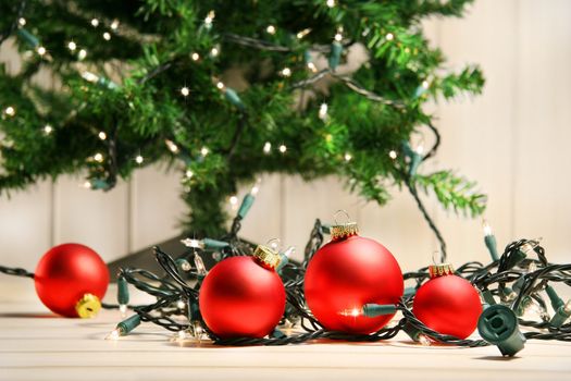 Red glass balls with lights under the christmas tree