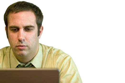 A young business man working from home on his laptop.  Plenty of copy space - image includes clipping path.