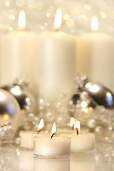 White votive candles with tall candles in background