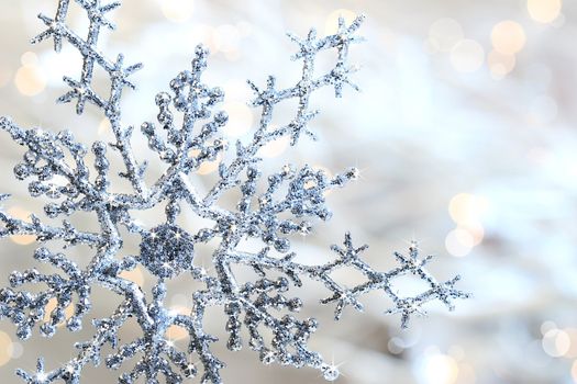 Silver blue snowflake against a shimmering background against a shimmering background