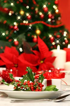 Festive holiday table with holly and poinsettias