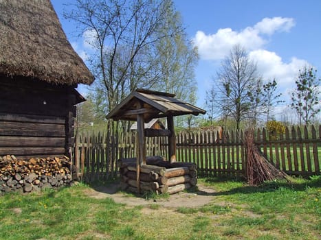 Old wooden hut in village, green grass around