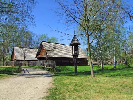 Old wooden hut in village, green grass around