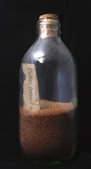 A bottle of sand with a small note.