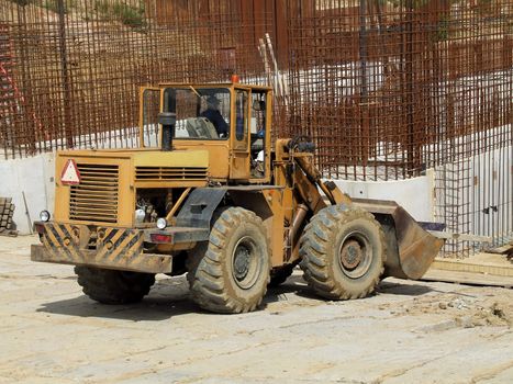 Front loader unloading concrete rubble on urban construction site