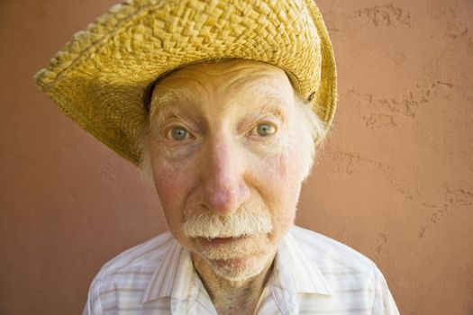 Senior Citizen Man with a Funny Expression Wearing a Straw Cowboy Hat