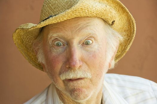 Senior Citizen Man with a Funny Expression Wearing a Straw Cowboy Hat