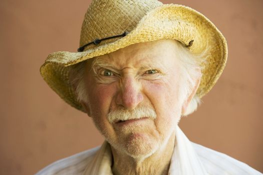 Senior Citizen Man Frowning n a Straw Cowboy Hat