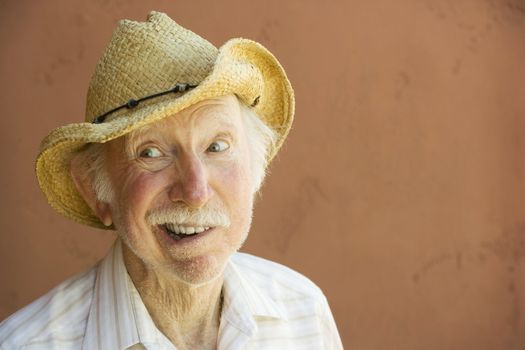 Senior Citizen Man Smiling in a Straw Cowboy Hat With Copy Space