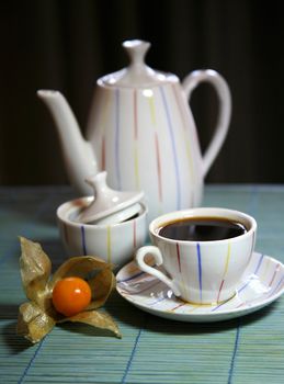 Two cups and a teapot on a green wooden napkin