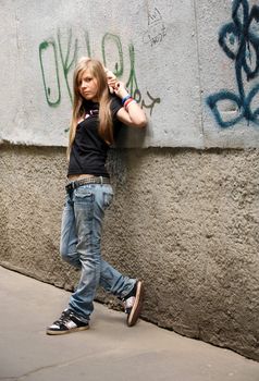 The girl - teenager on a background of a wall