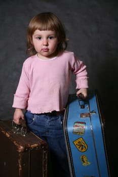 The little girl with two old suitcases