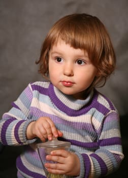 Portrait of the two-year-old girl with a bottle in hands