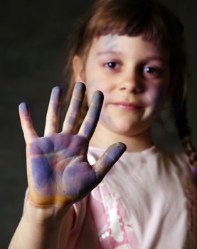 The good little girl. Hands and the face are soiled in a paint