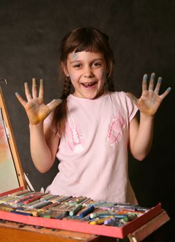 The good little girl. Hands and the face are soiled in a paint
