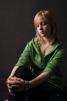The young girl in green clothes on a black background.