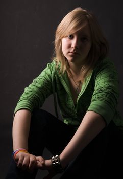 The young girl in green clothes on a black background.