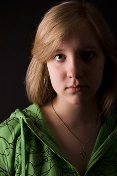 The young girl in green clothes on a black background.