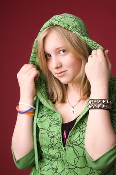 The young girl in green clothes on a red background.