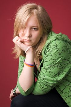 The young girl in green clothes on a red background.